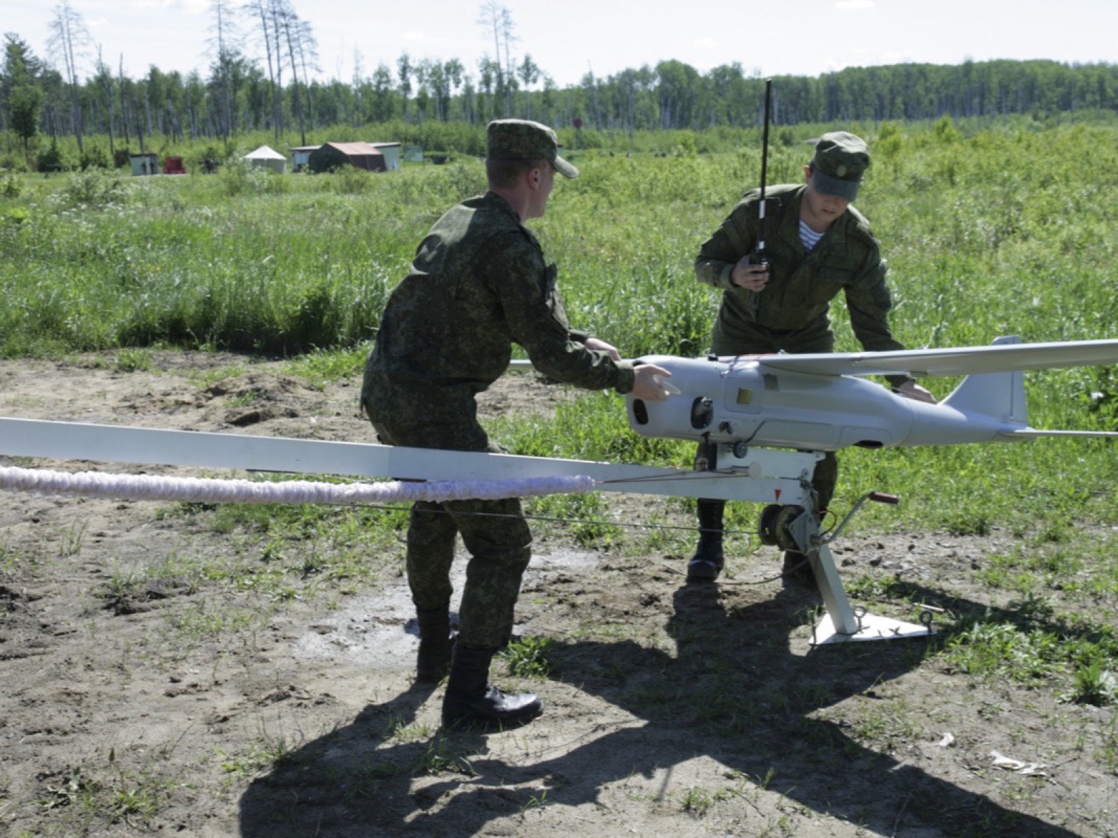 Двое военнослужащих на поле готовят беспилотник «Орлан-10» к запуску с катапульты